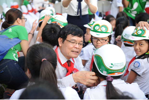 PGS.TS.BS Thầy thuốc nhân dân Nguyễn Xuân Thành – đại diện Bệnh viện Đa khoa Quốc tế Thu Cúc đang trực tiếp đội mũ bảo hiểm cho các em học sinh.