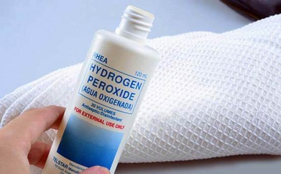 Đổ nước oxy già lên bông tẩy trang, thoa trực tiếp dung dịch đó lên da.